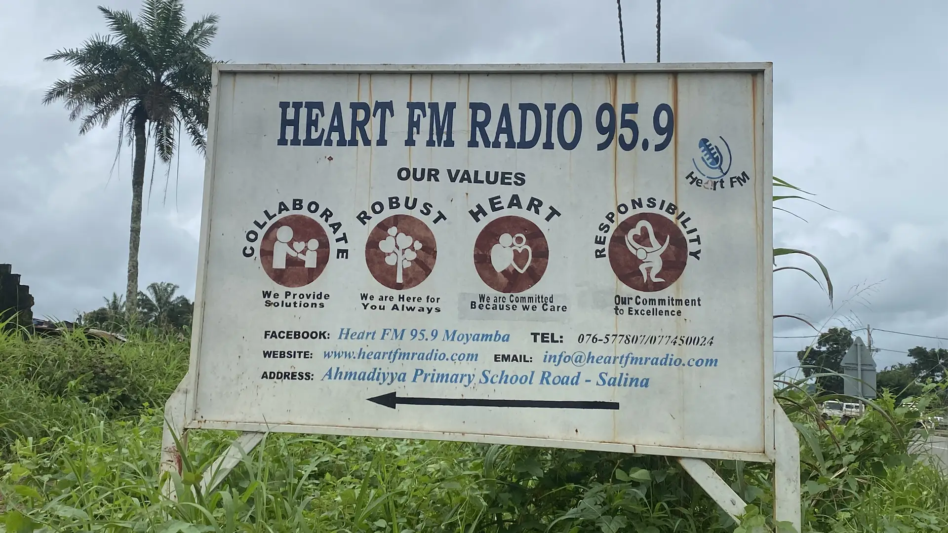 A large wooden sign beside a road advertising Heart FM Radio 95.9